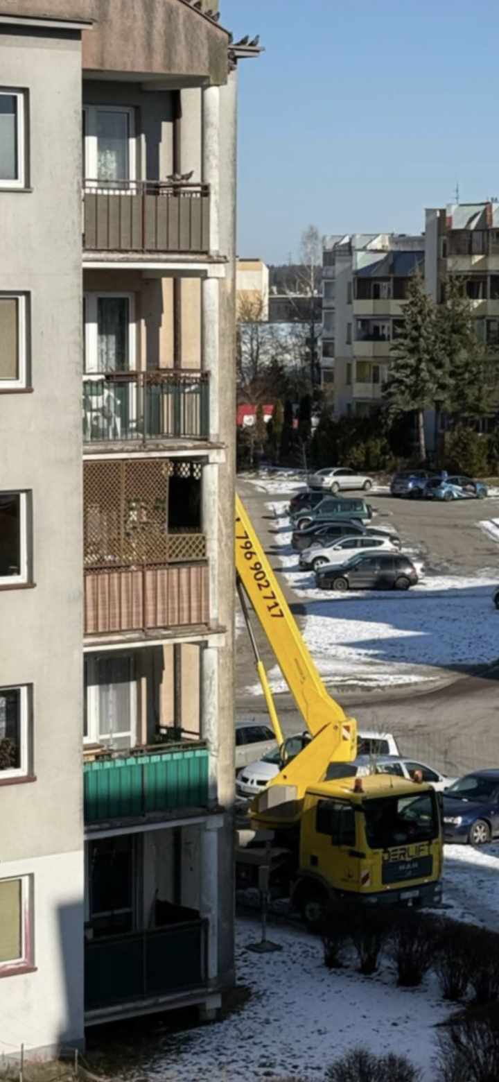 Wiele gołębi na dachu i balkonie 4-piętrowego bolku